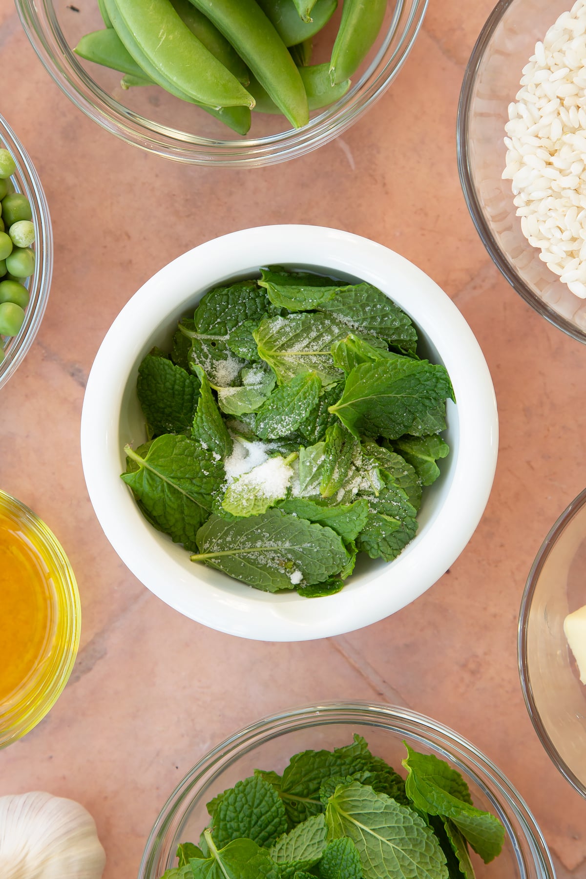 Overhead shot of salt and mint in a mortar.