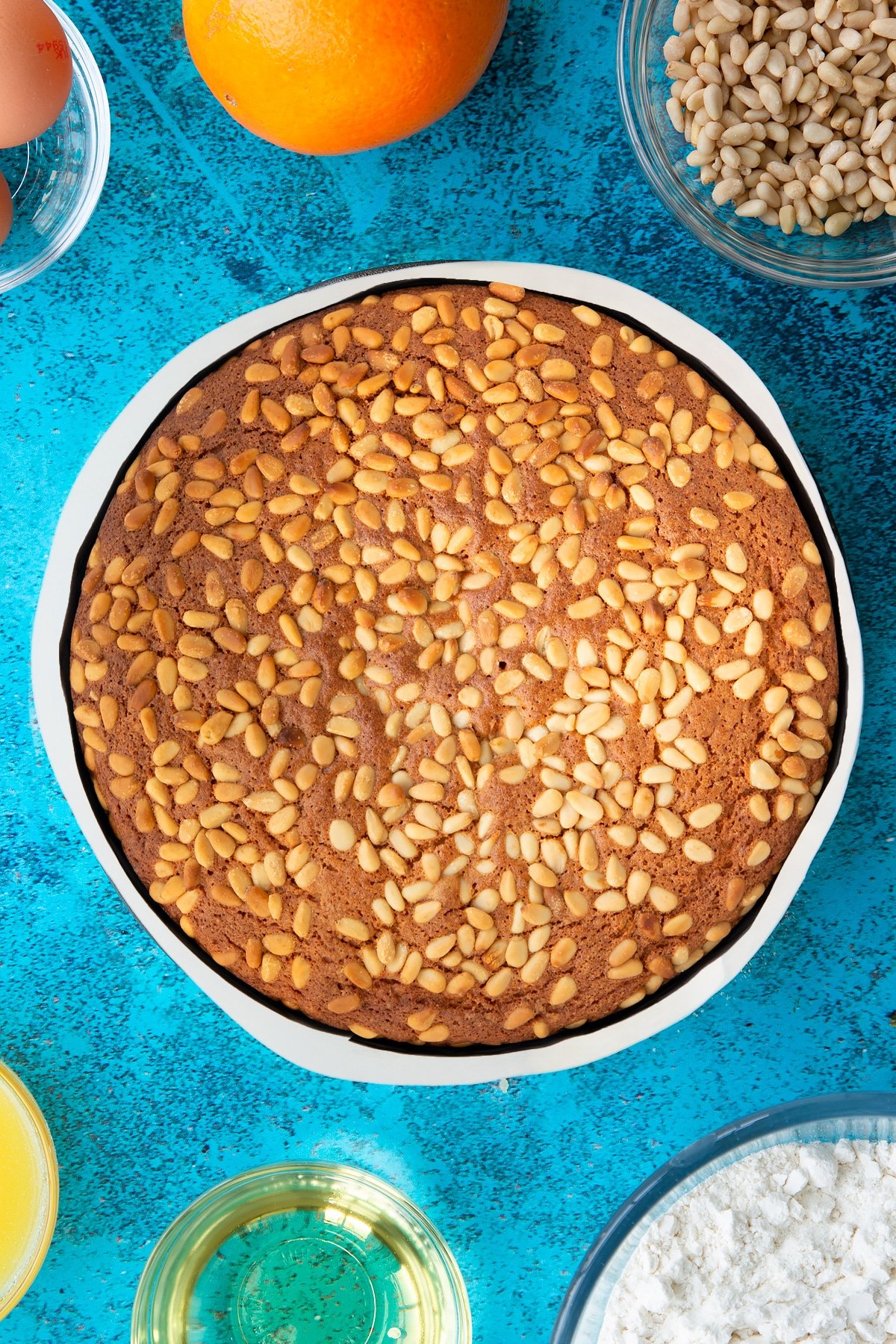 Freshly baked pine nut cake in a lined tin.