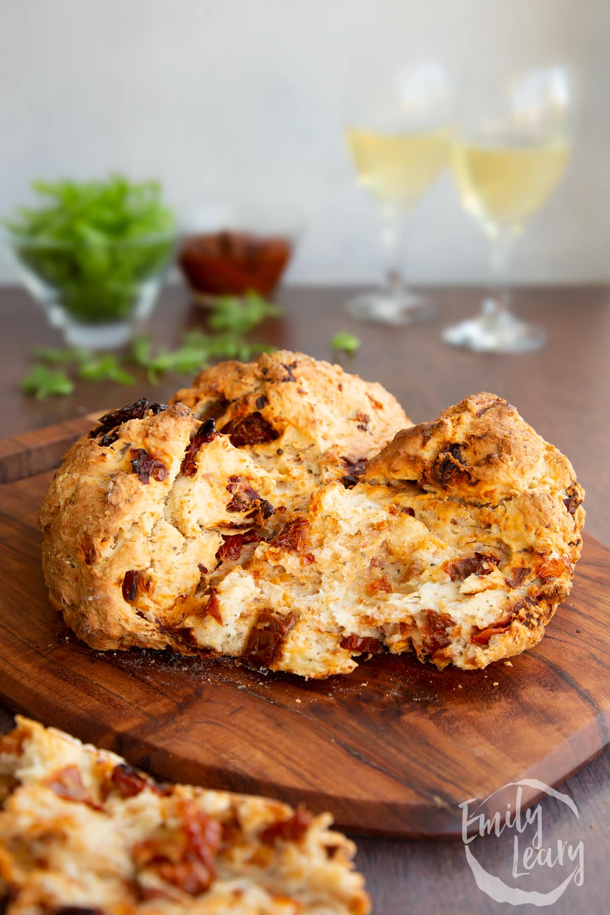 Sundried tomato soda bread on a board. It has been broken open.