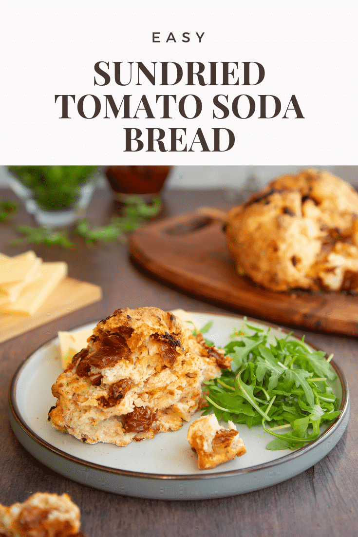 A piece of sundried tomato soda bread on a plate with salad. Caption reads: Easy Sundried tomato soda bread