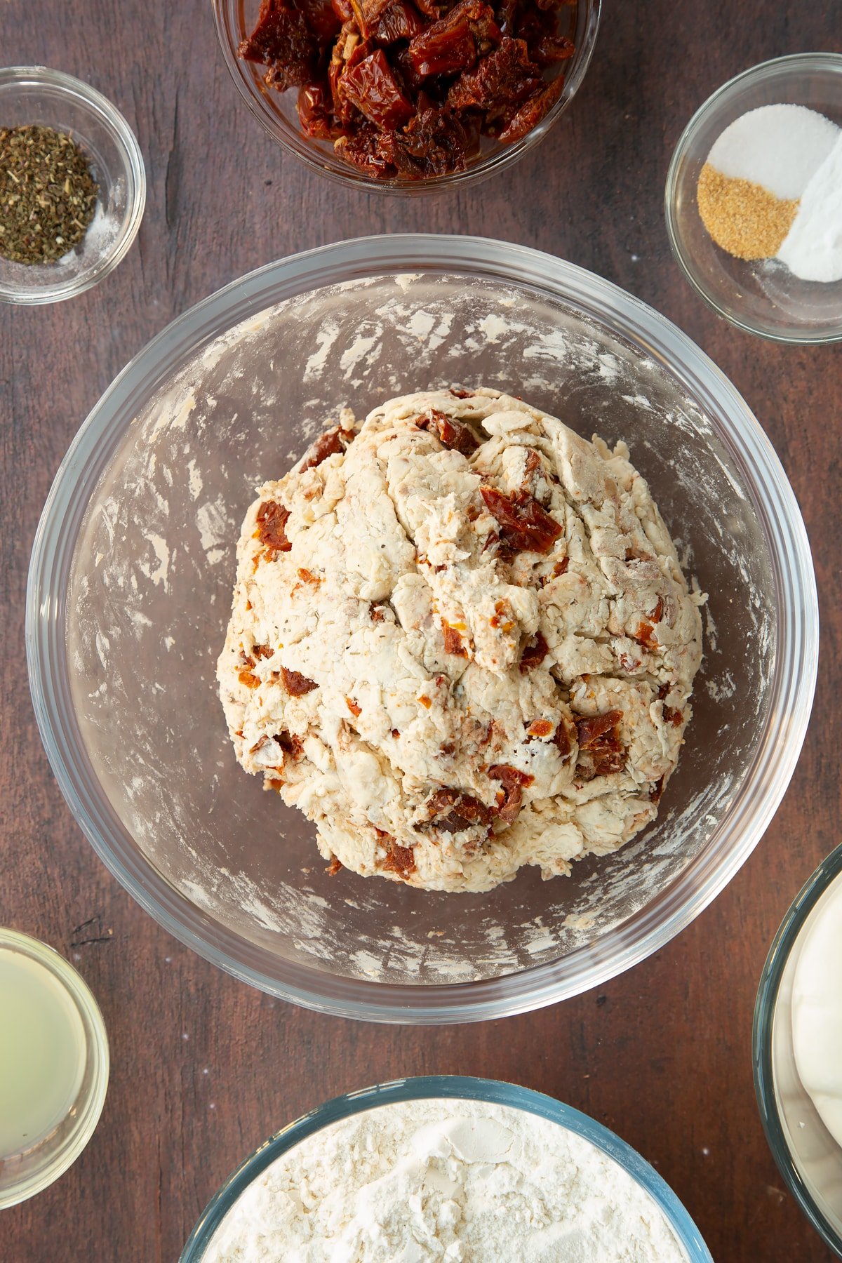 Sundried tomato soda bread dough gathered into a ball in a bowl.