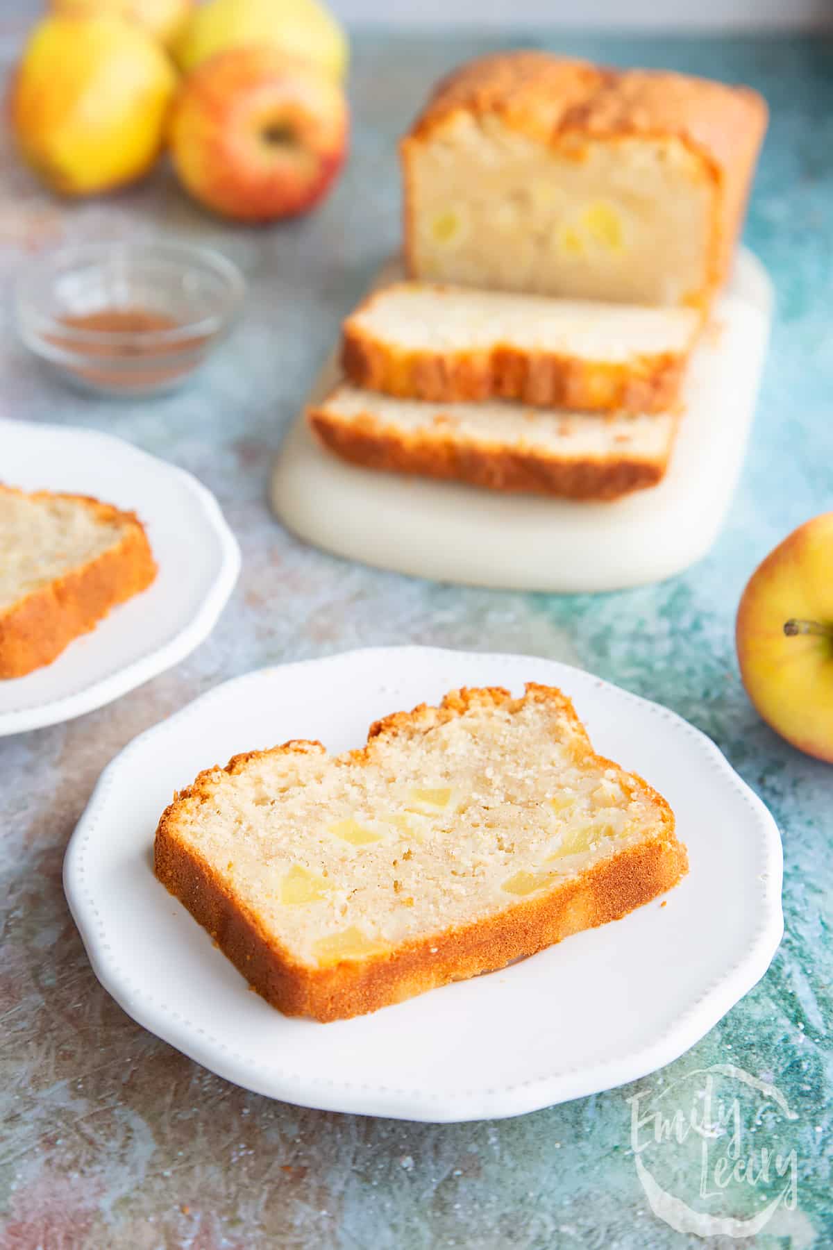 Slice of apple cake on a white decorative plate.