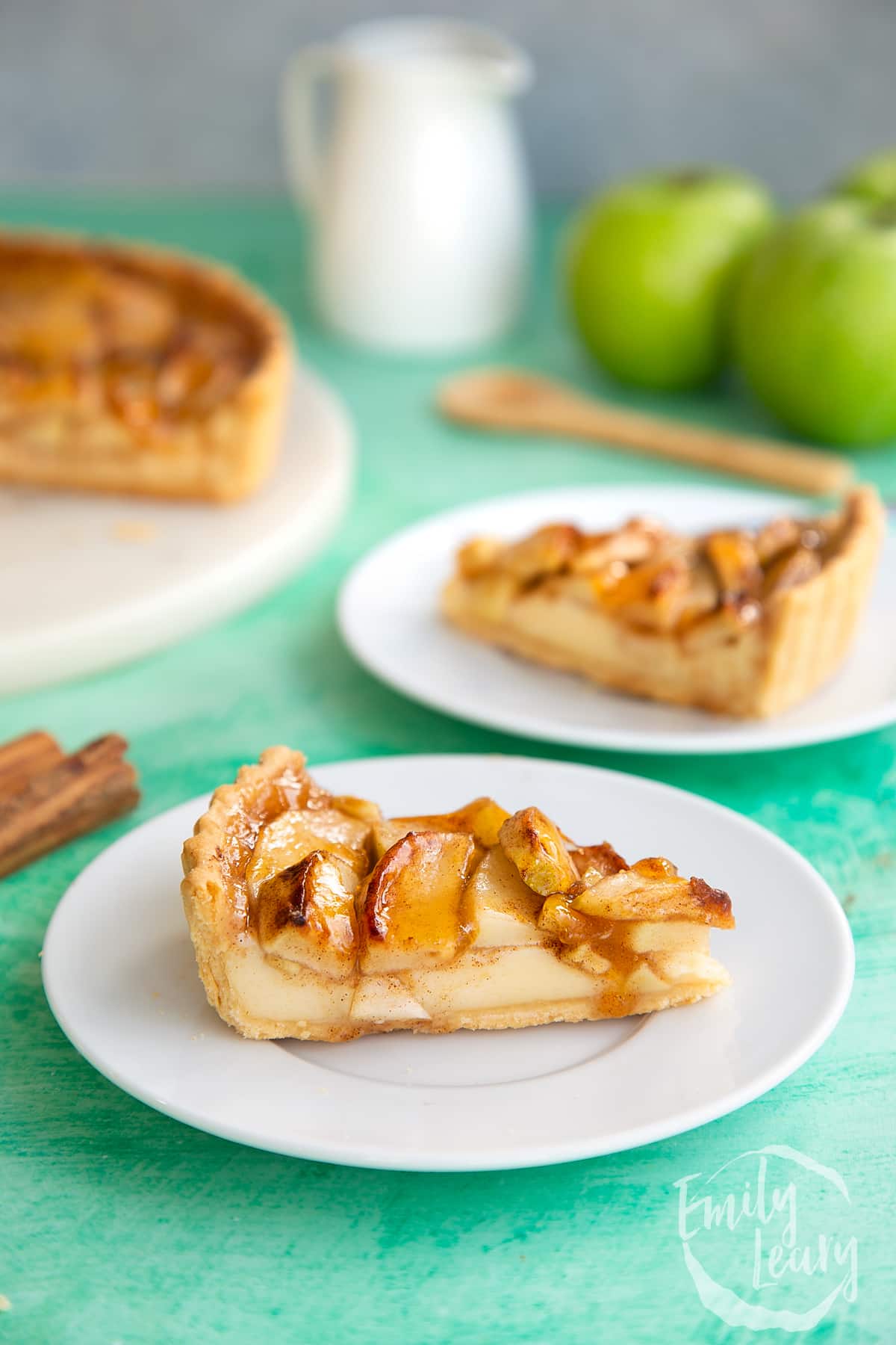 Apple custard tart slice on a white plate. 