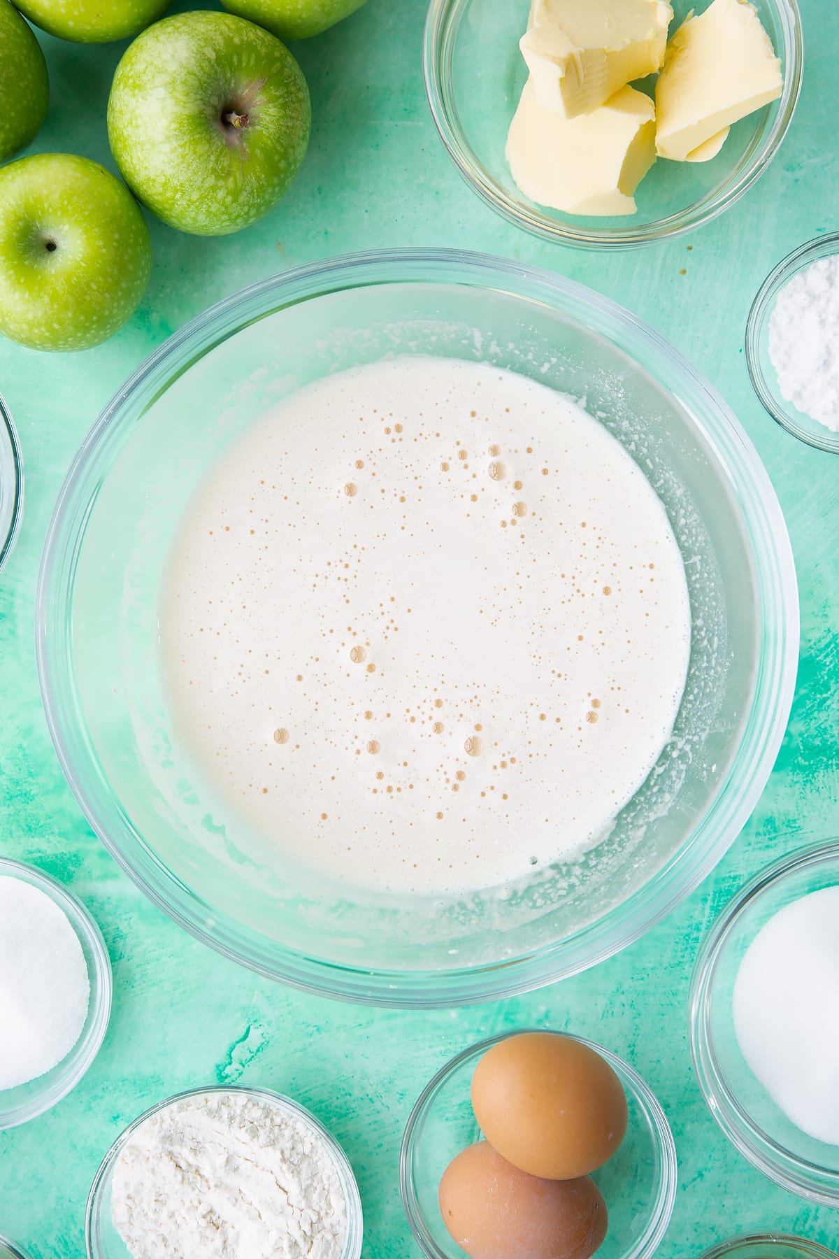 Adding the milk to the custard ingredients inside the mixing bowl.