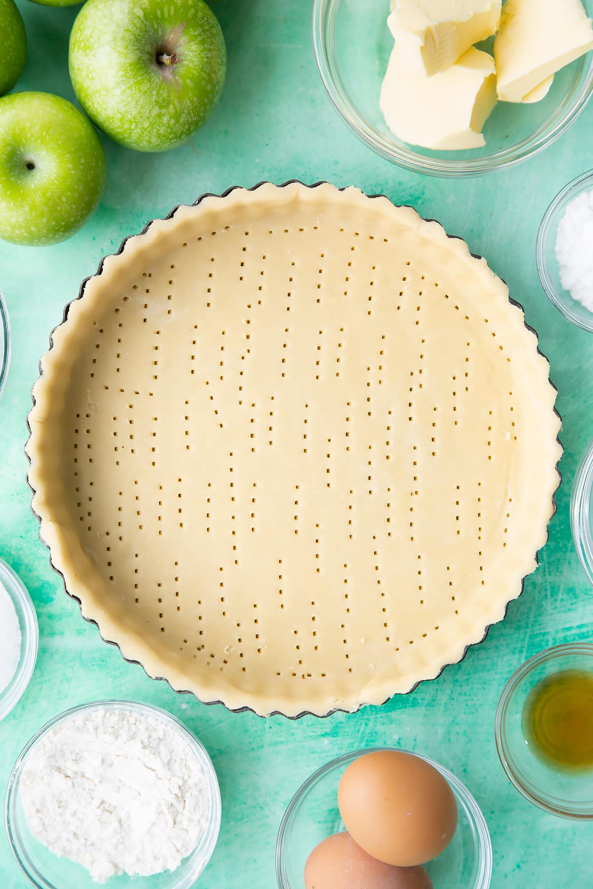 Overhead shot of the pastry tin having been priked with a fork multiple times.