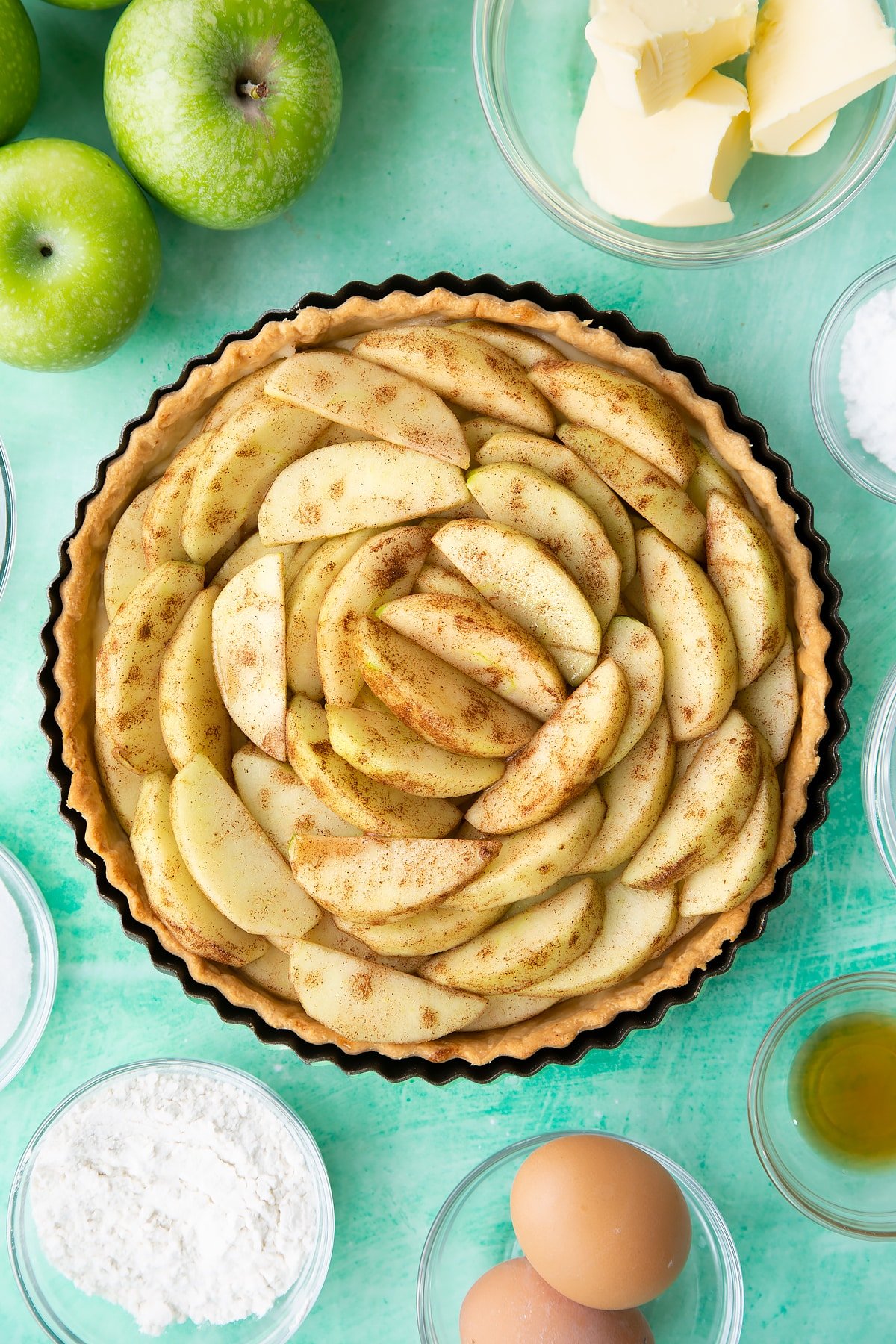 Adding the apples to the pastry tin ontop of the custard.