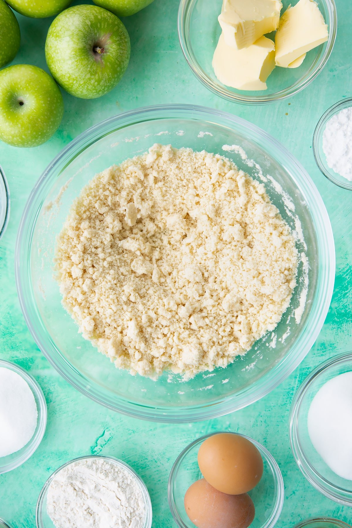 Overhead shot of the apple custard tart pastry mixture having added two tablespoons of cold water to the mix.