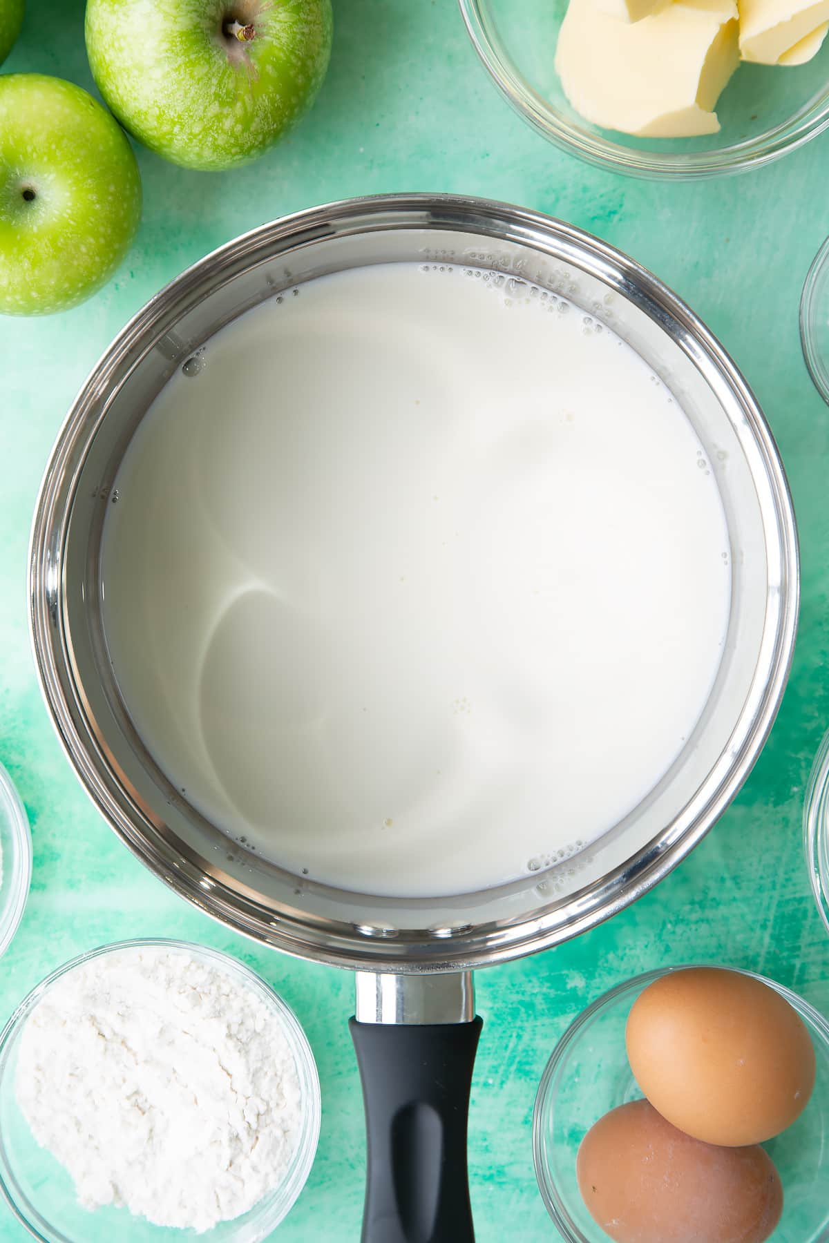 Warming milk in a pan until it's close to the boil.