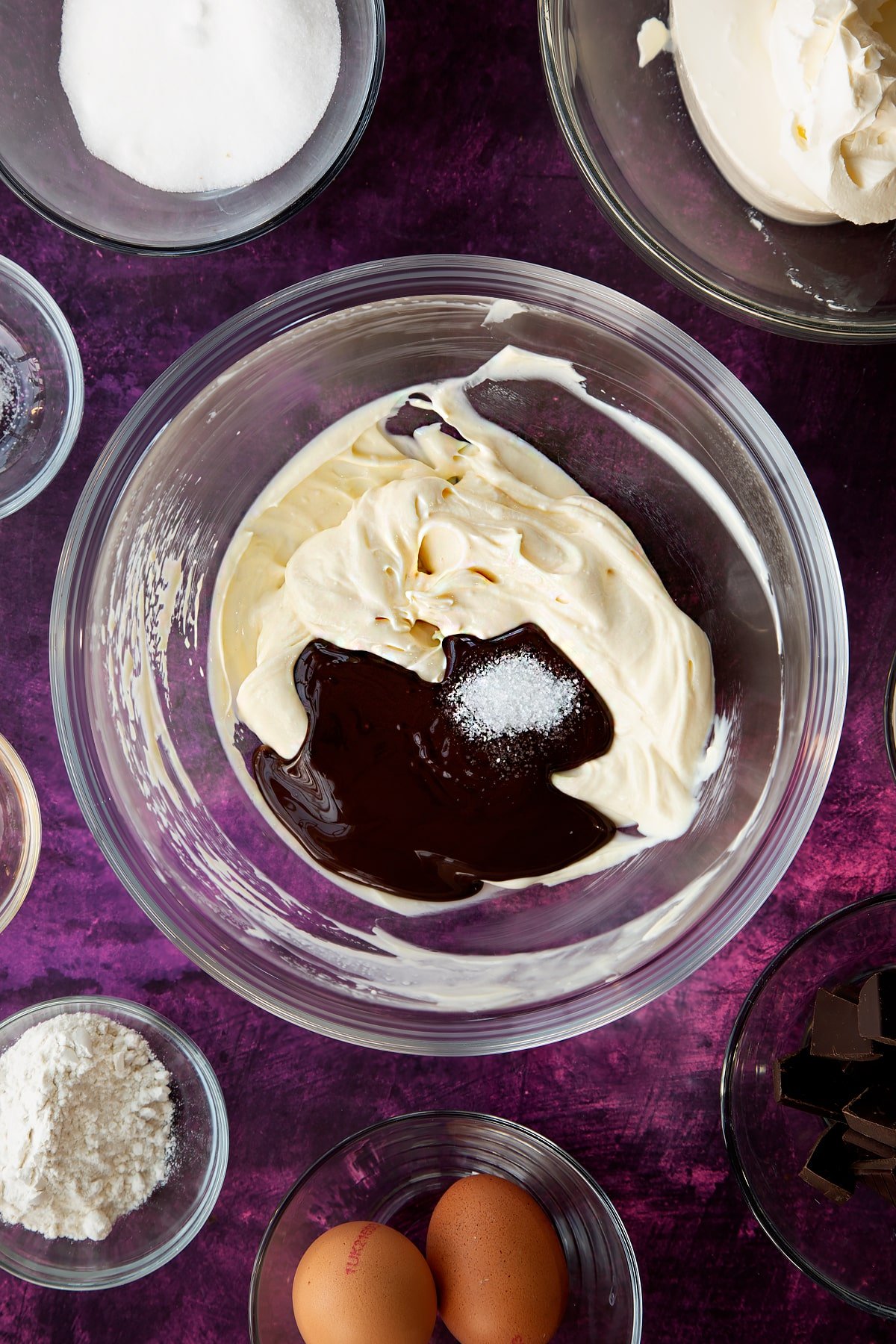 Adding cooled melted chocolate to a quarter of the marble cheesecake mixture.