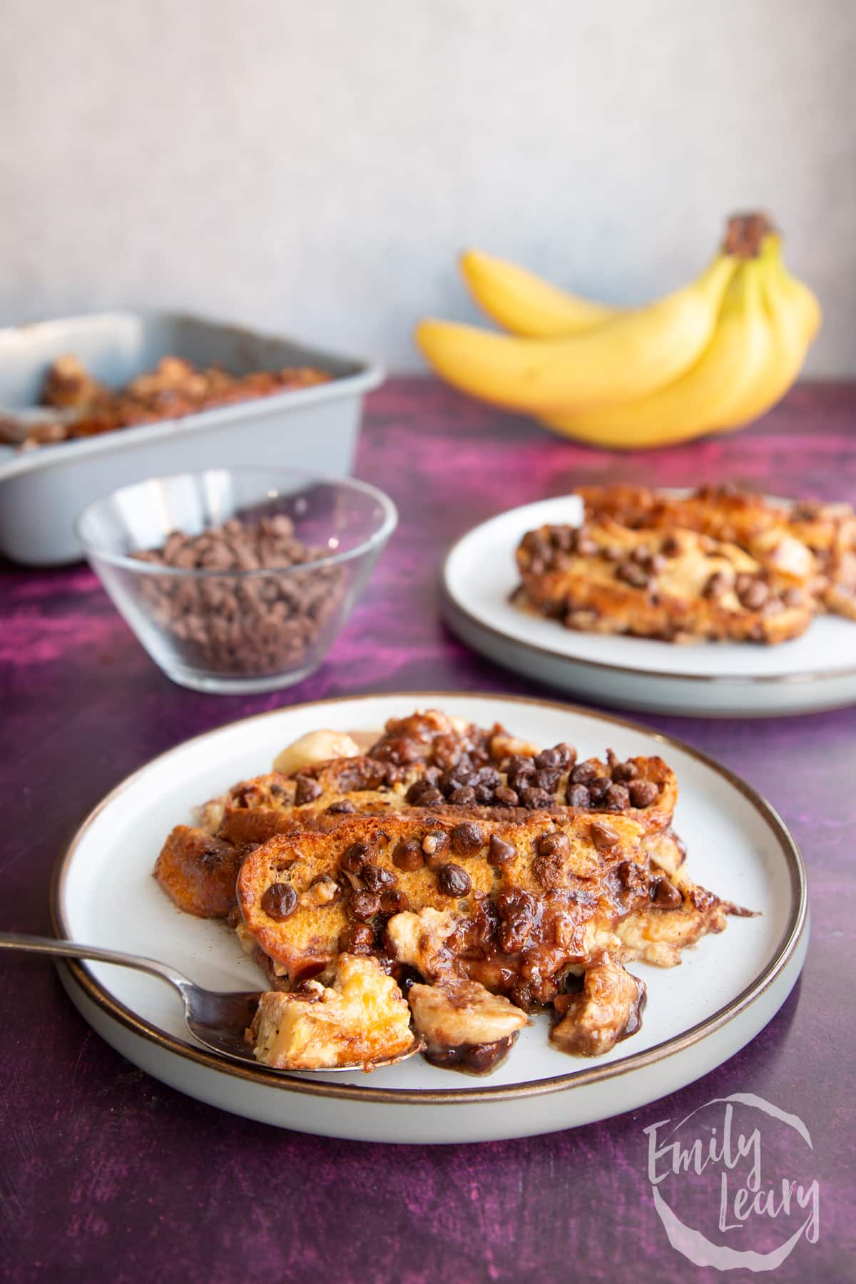 Side on shot of the finished chocolate banana bread pudding served on a decorative plate.