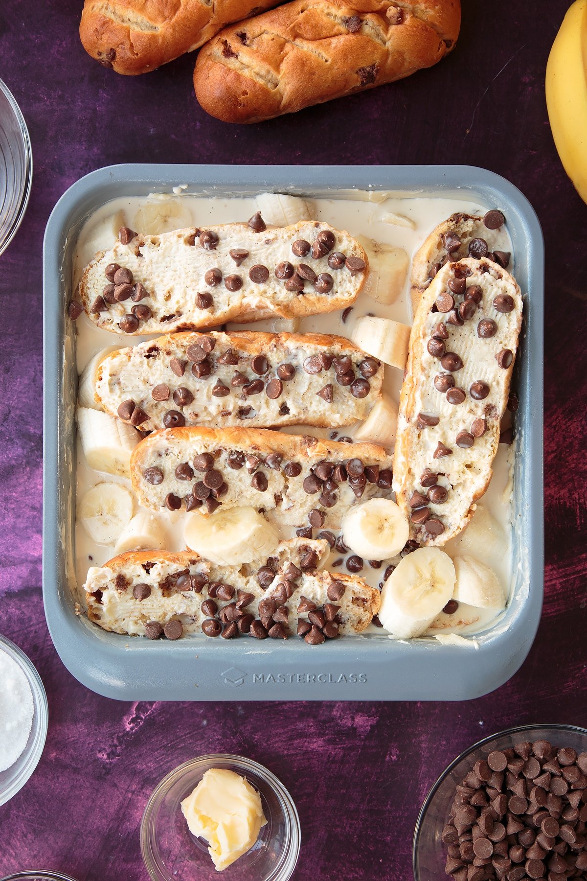 Adding the wet ingredients for the chocolate banana bread pudding and slices of banana.