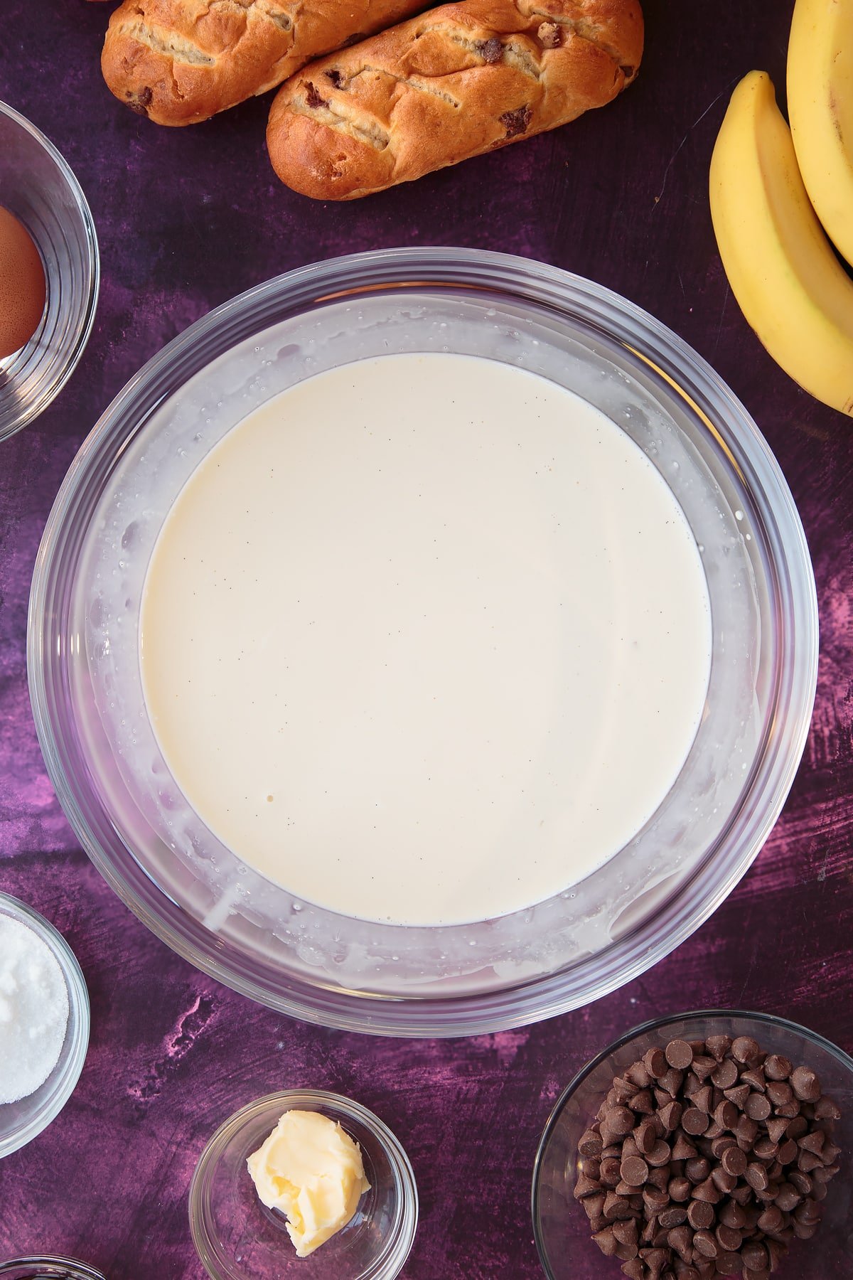 Overhead shot of the chocolate banana bread pudding wet ingredients mixed together in a mixing bowl.