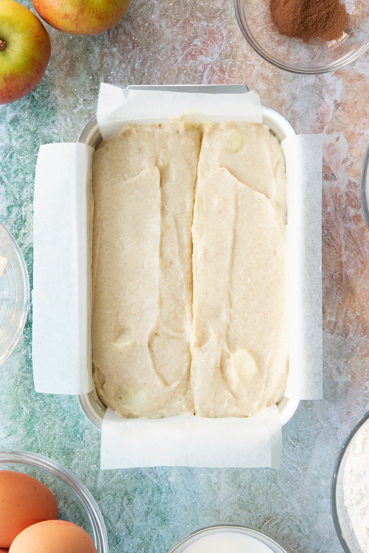 Overhead shot of the spiced apple cake mixture in a loaf tin.