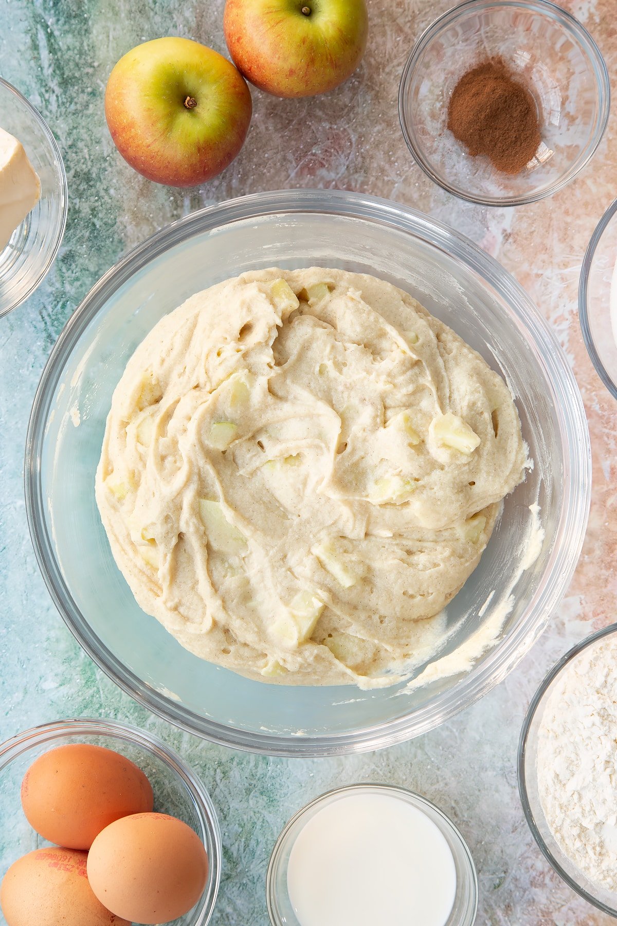 Folding in the apple pieces into the cake batter.