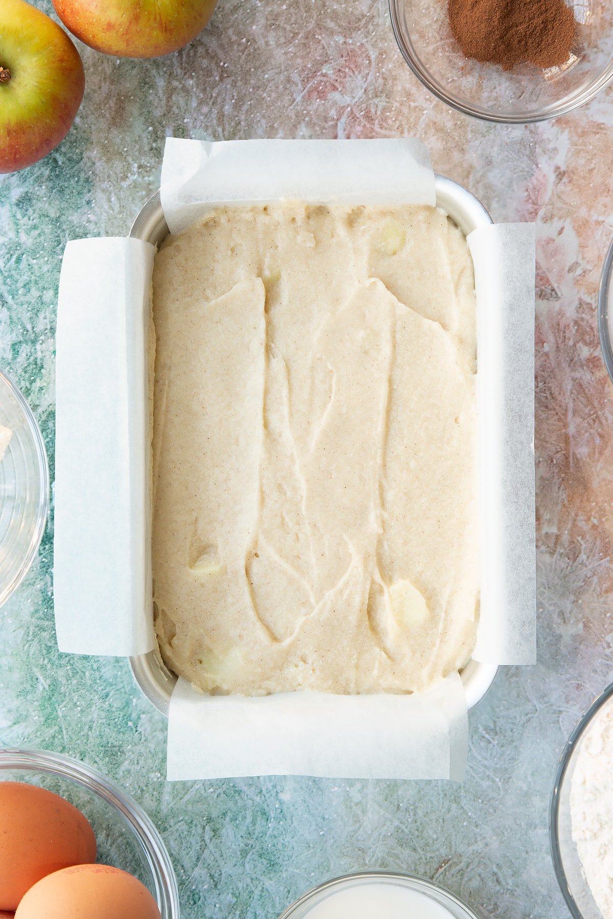 Loaf tin filled with the spiced apple cake mixture.