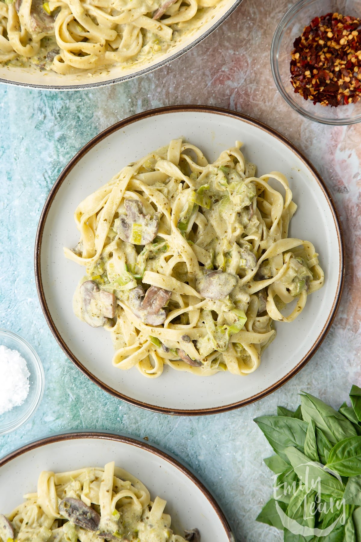 Overhead shot of the finished leek and pesto pasta served on a decorative plate.