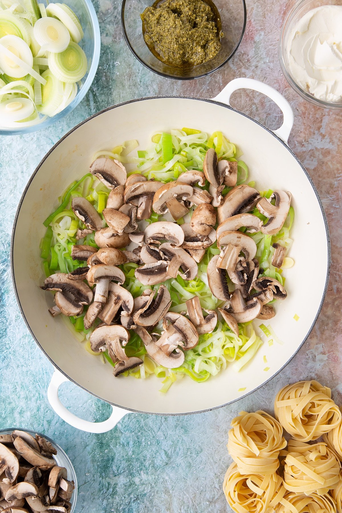 Overhead shot of sliced mushrooms being added to the pan.