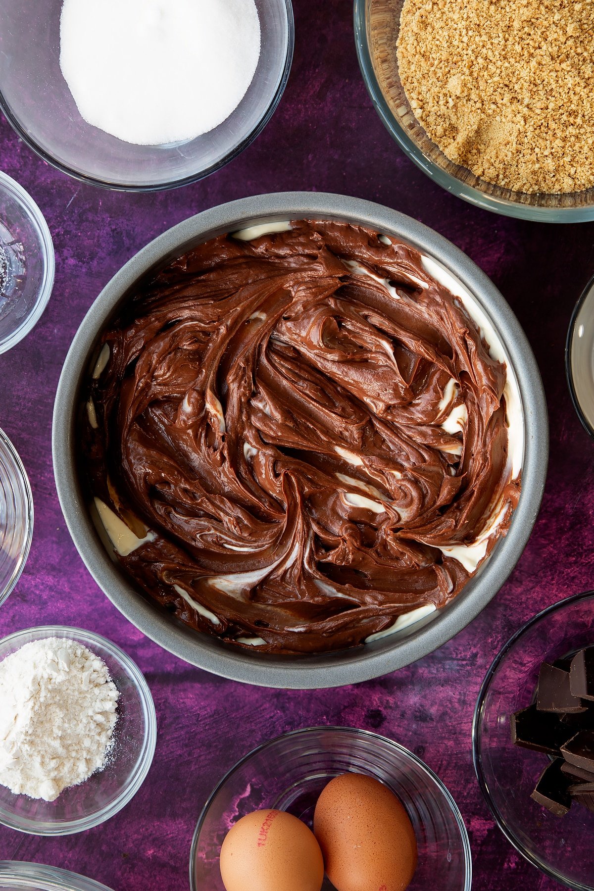 Swirling the chocolate cream cheese and the origional cream cheese fillings together in the non-stick cake tin.