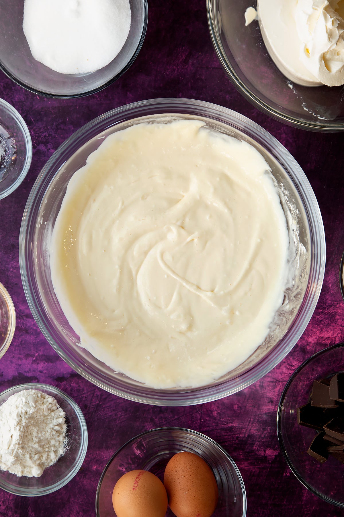 Overhead shot of a mixing bowl filled with smooth marble cheesecake filling.