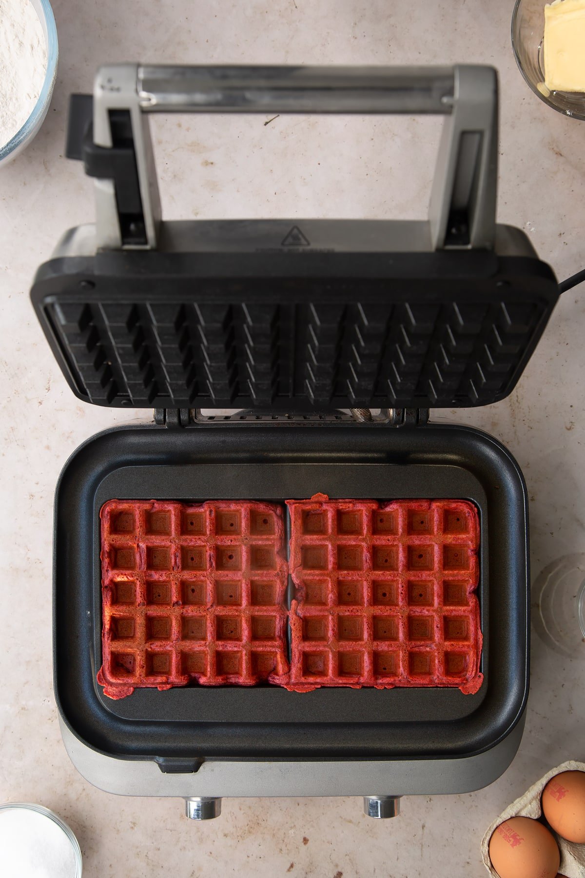 Overhead shot of the finished red velvet waffles having been in the waffle maker for between 3 and 5 minutes.