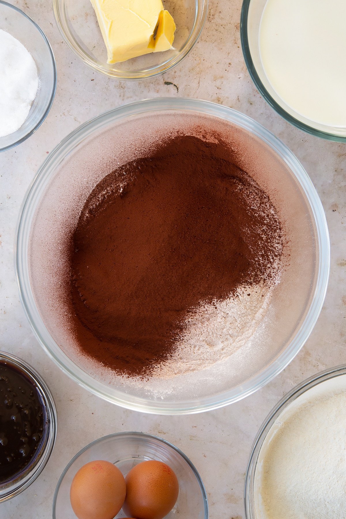 Overhead shot of the cocoa and flour being added to the bowl of ingredients.