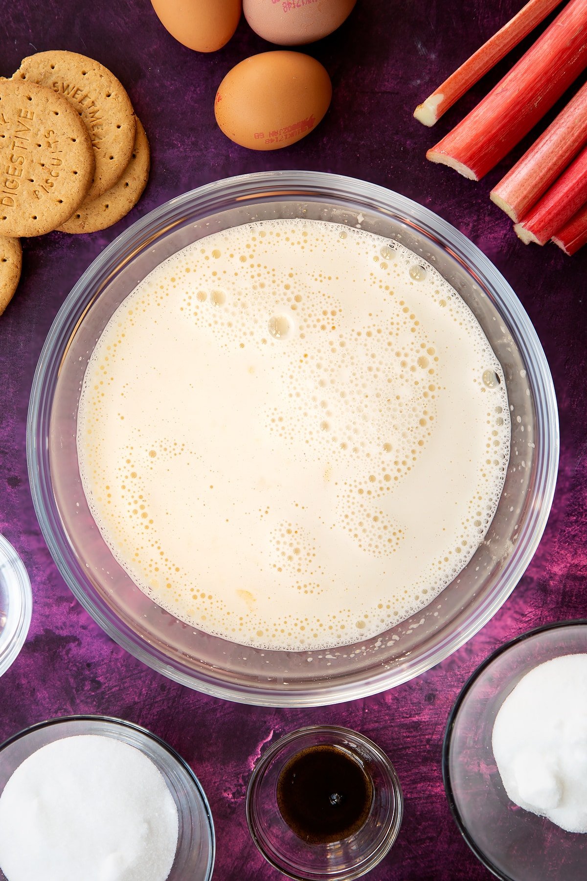 custard mix bubbling and frothing in a clear glass mixing bowl. 