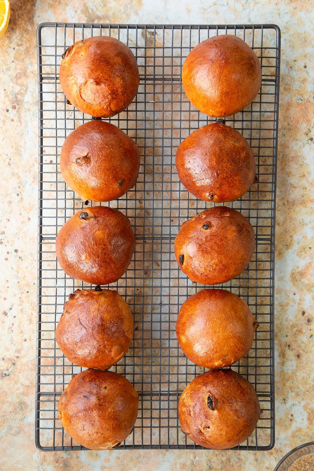 Overhead shot of the spiced fruit buns cooling on the cooling rack.