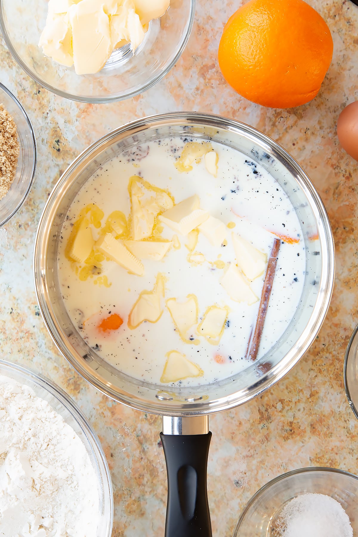 Overhead shot of a pan filled with the ingredients for spiced fruit buns.