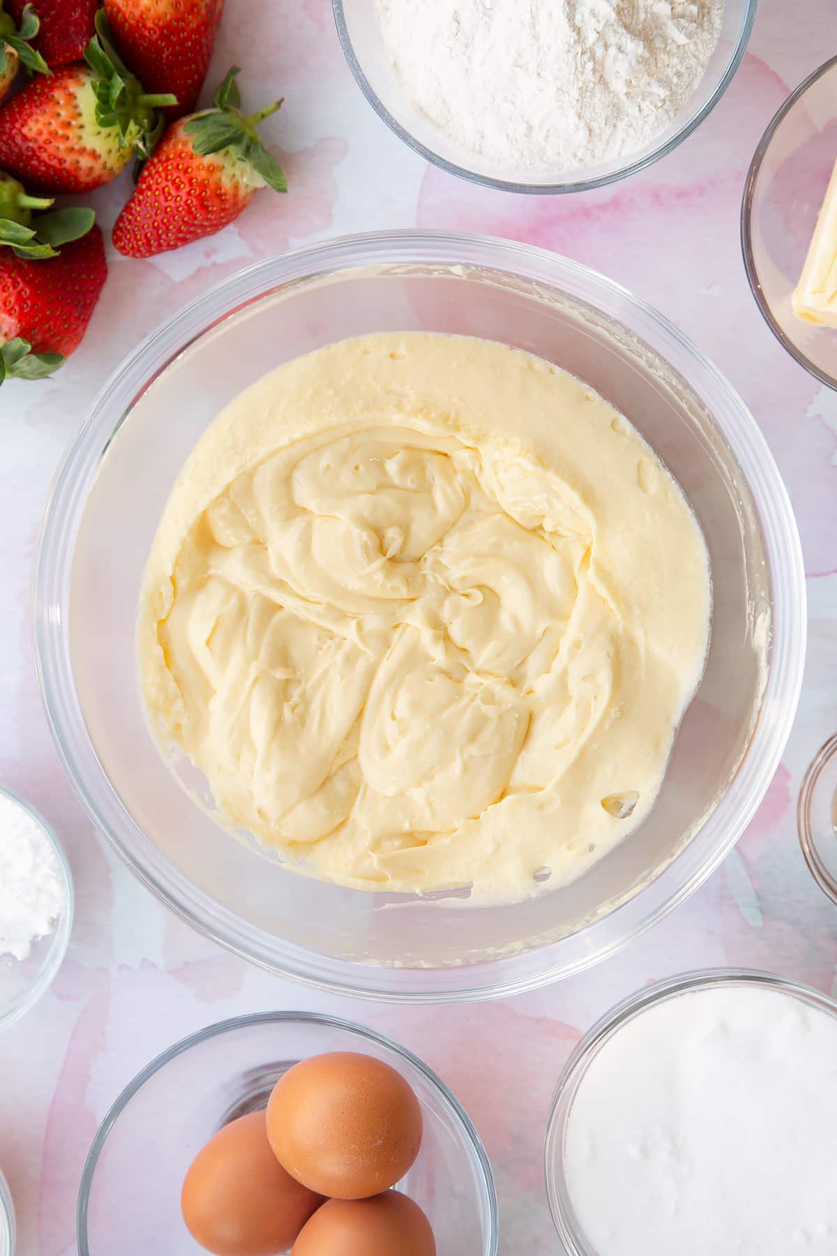 creamed butter, sugar and egg mixture in a large clear bowl with ingredients around the edges