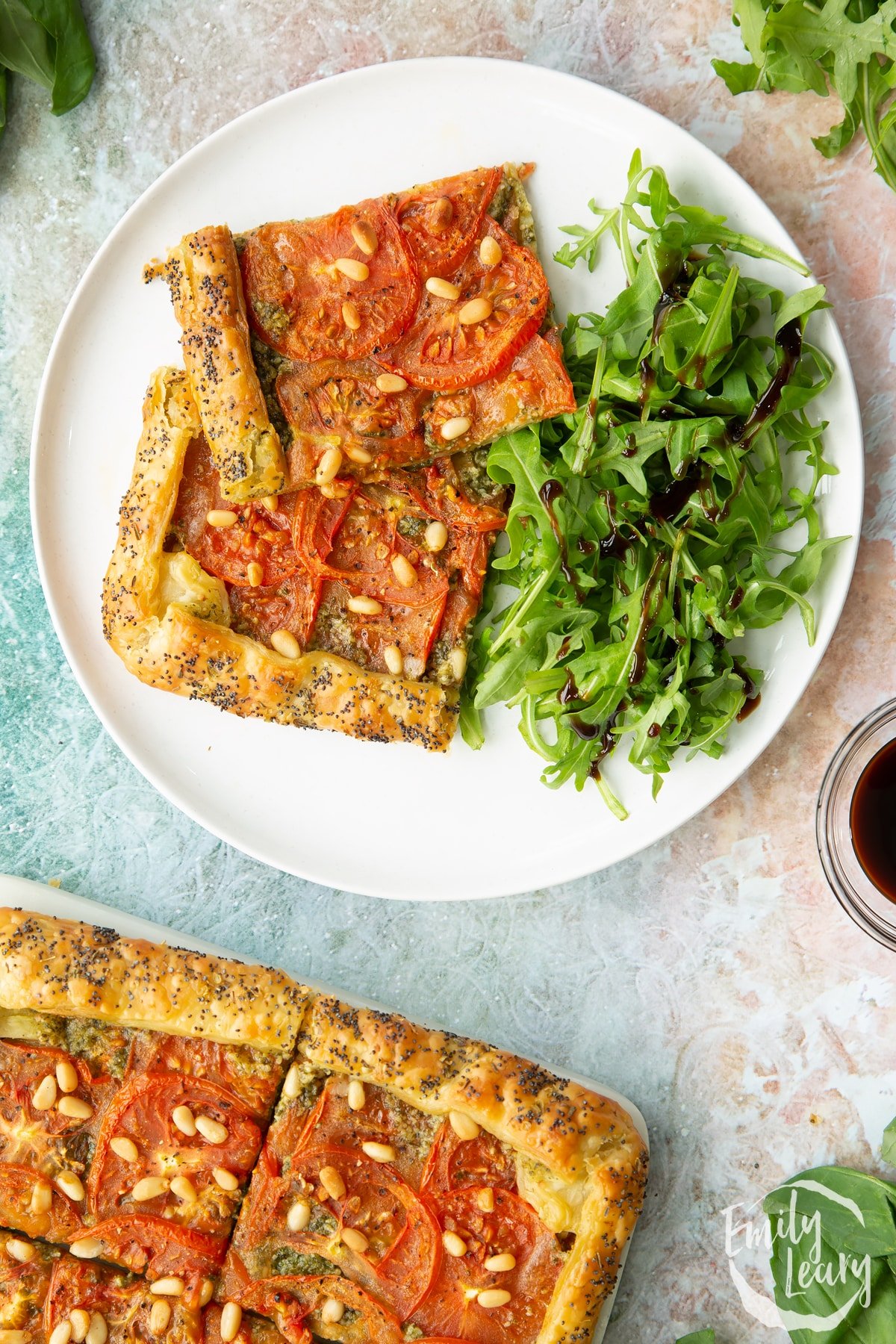 Two slices of the finished vegan puff pastry tart served with a side salad on a white plate.