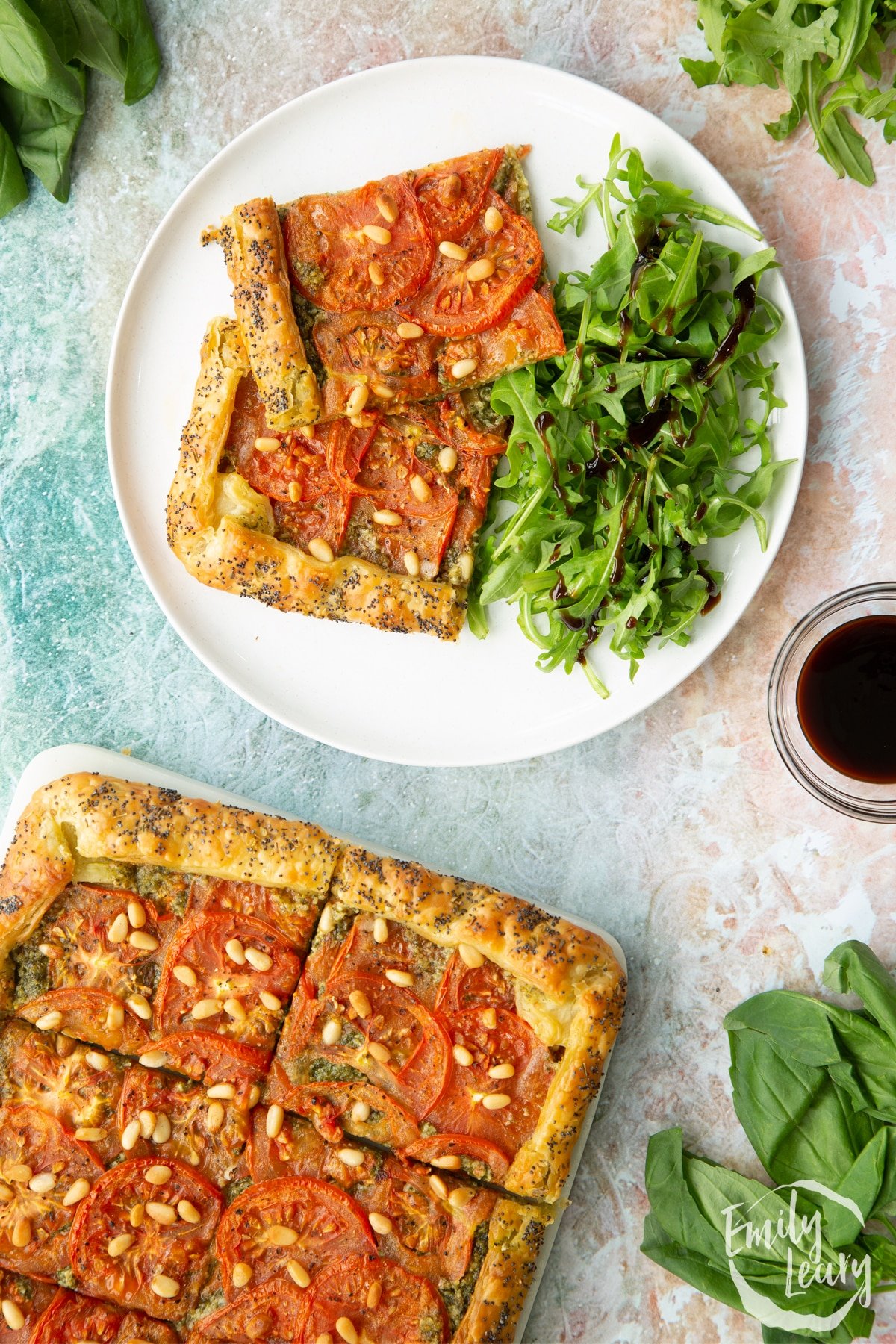 Two slices of the vegan puff pastry tart served with a side salad on a white decorative plate.