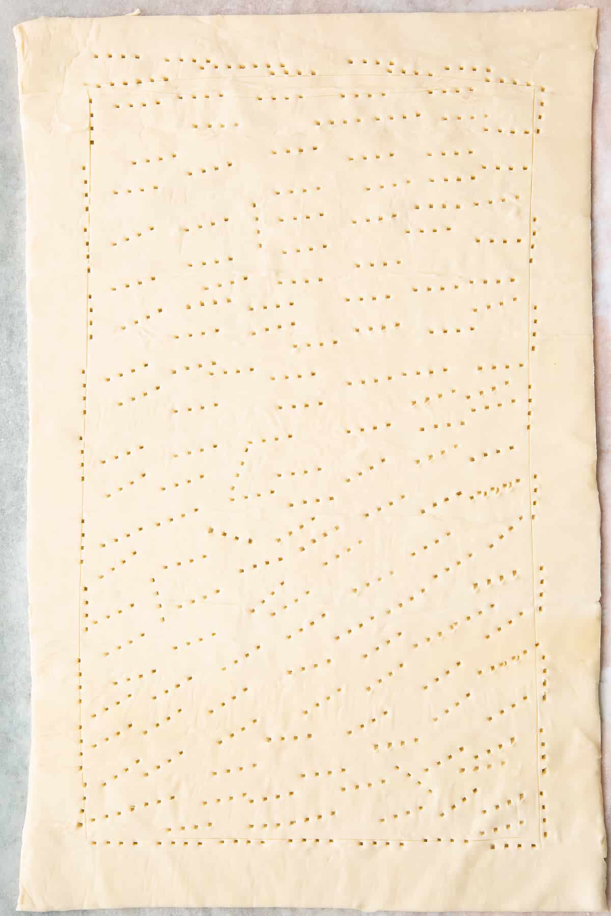 Overhead shot of the puff pastry having been pricked with a fork multiple times.