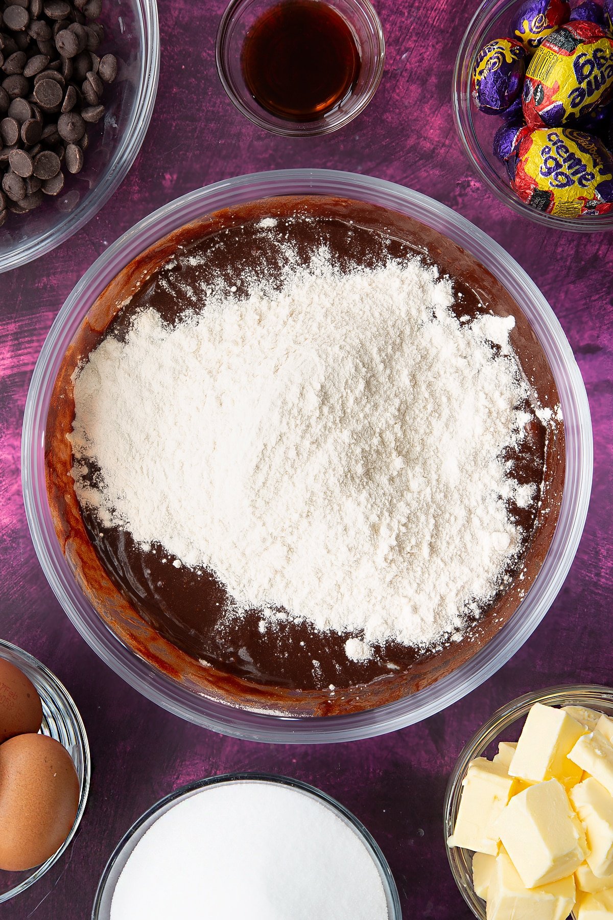 Flour on the top of the wet chocolate mixture inside a heatproof bowl.