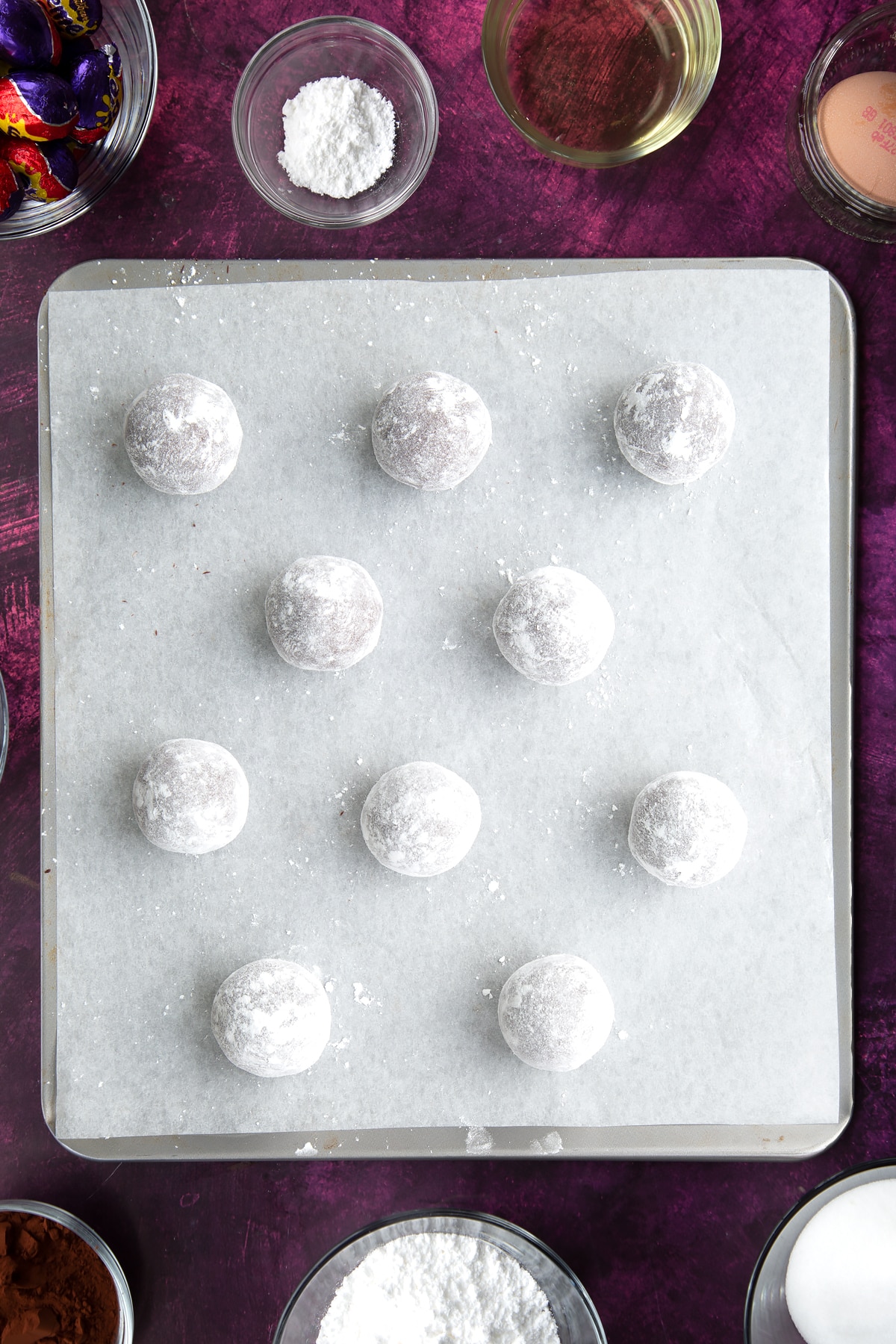 Dusting the balls with icing sugar.
