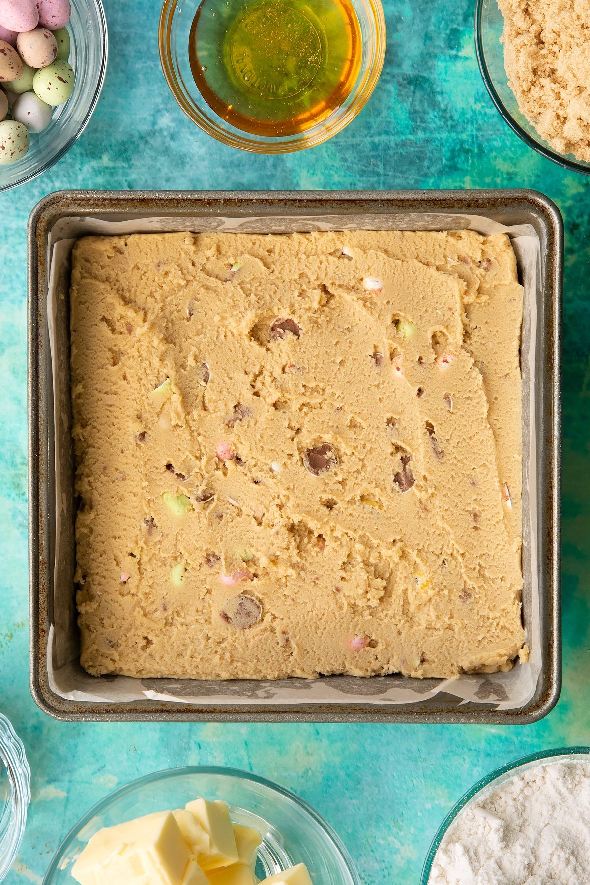 Overhead shot of the cookie dough mixture having been leveled off with a spoon.