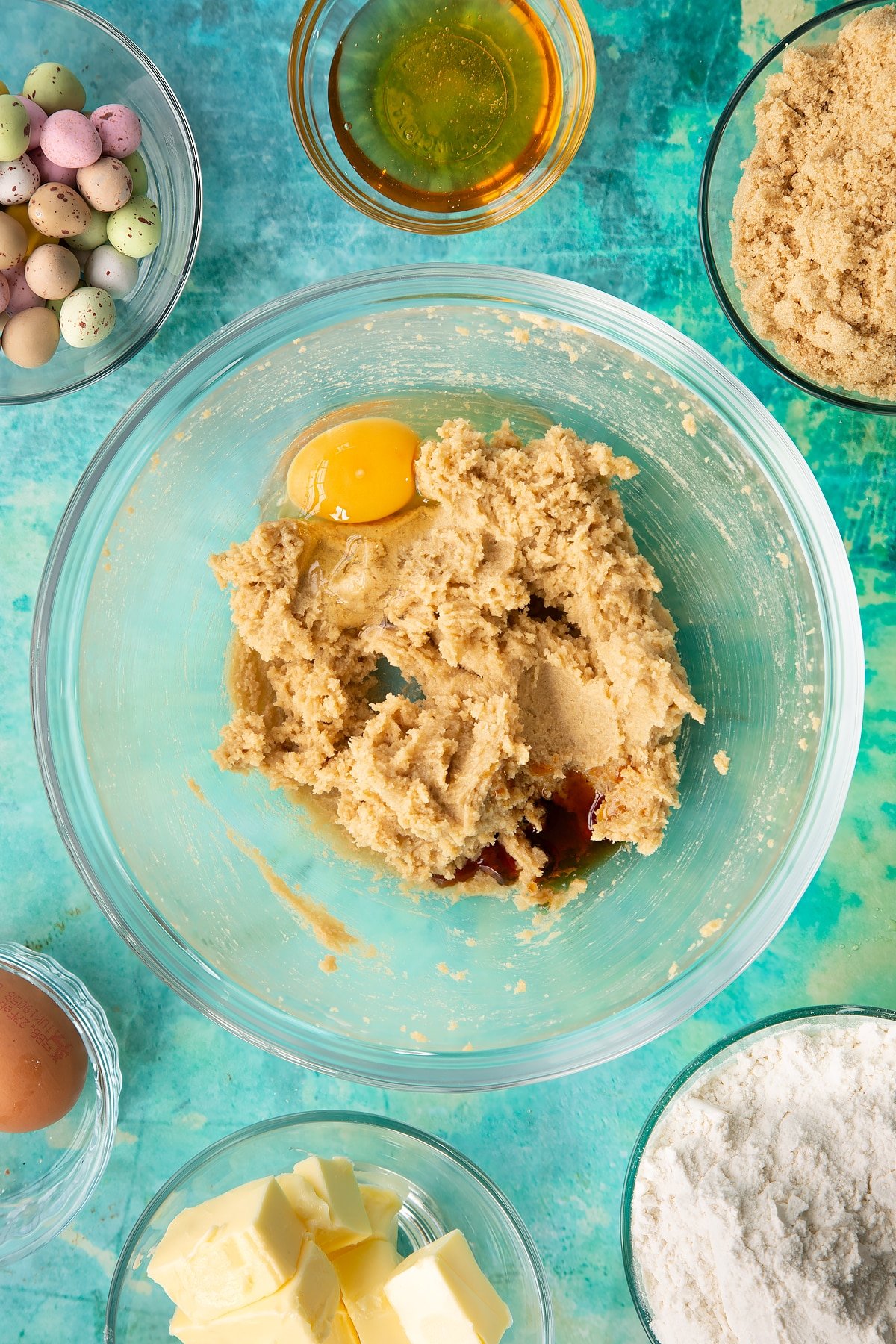 Adding egg and vanilla to the wet cookie bar mixture.