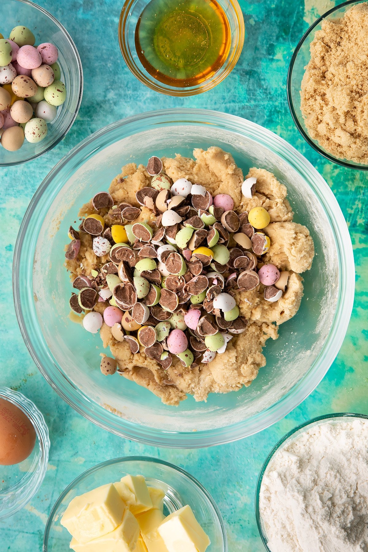 Adding the chopped mini eggs to the bowl of cookie bar mixture.