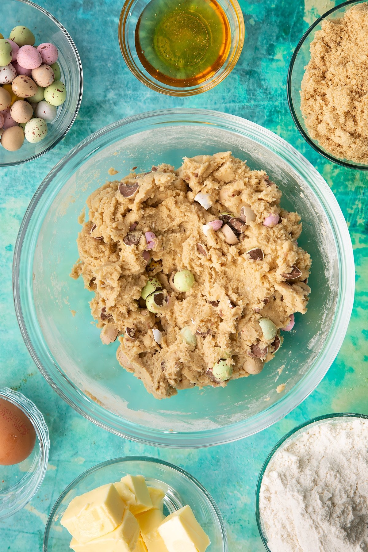 Folding the mini eggs into the cookie bar mixture.