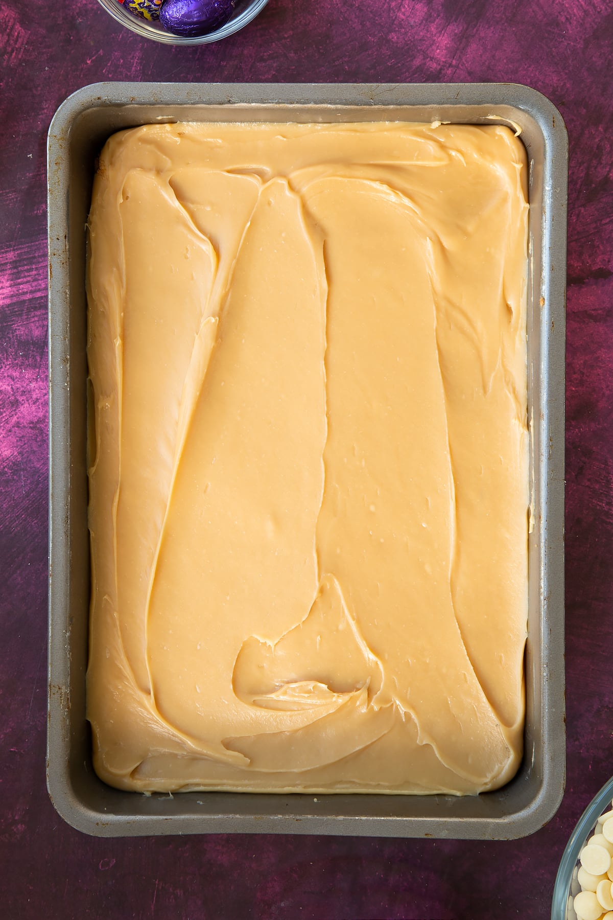 Smoothing the caramel out across the baking tin.