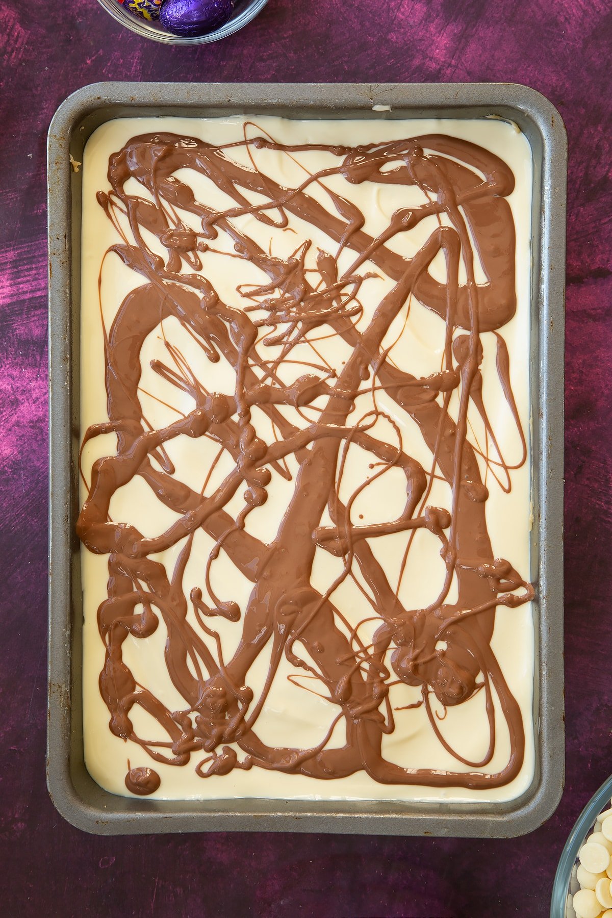 Overhead shot of the baking tin having had chocolate drizzled across the top.