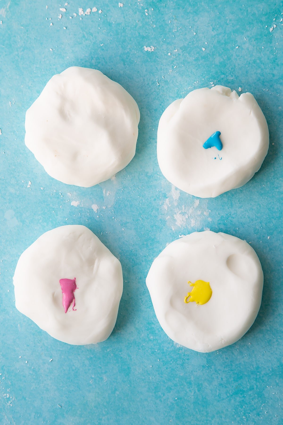 Four pieces of sugar paste with different food colouring on three pieces.