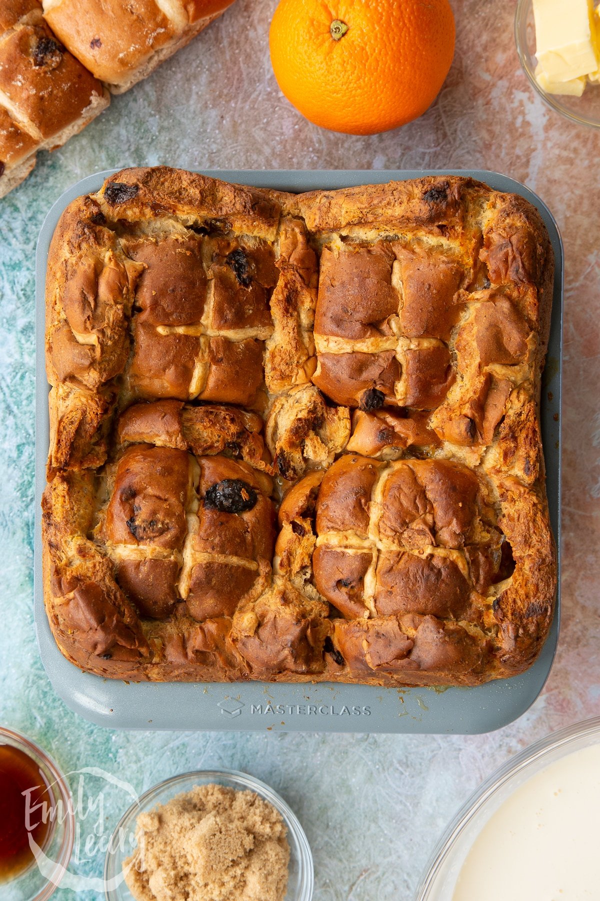 Ovehread shot of the hot cross bun bread and butter pudding tin after the tin has been in the oven for almost one hour.