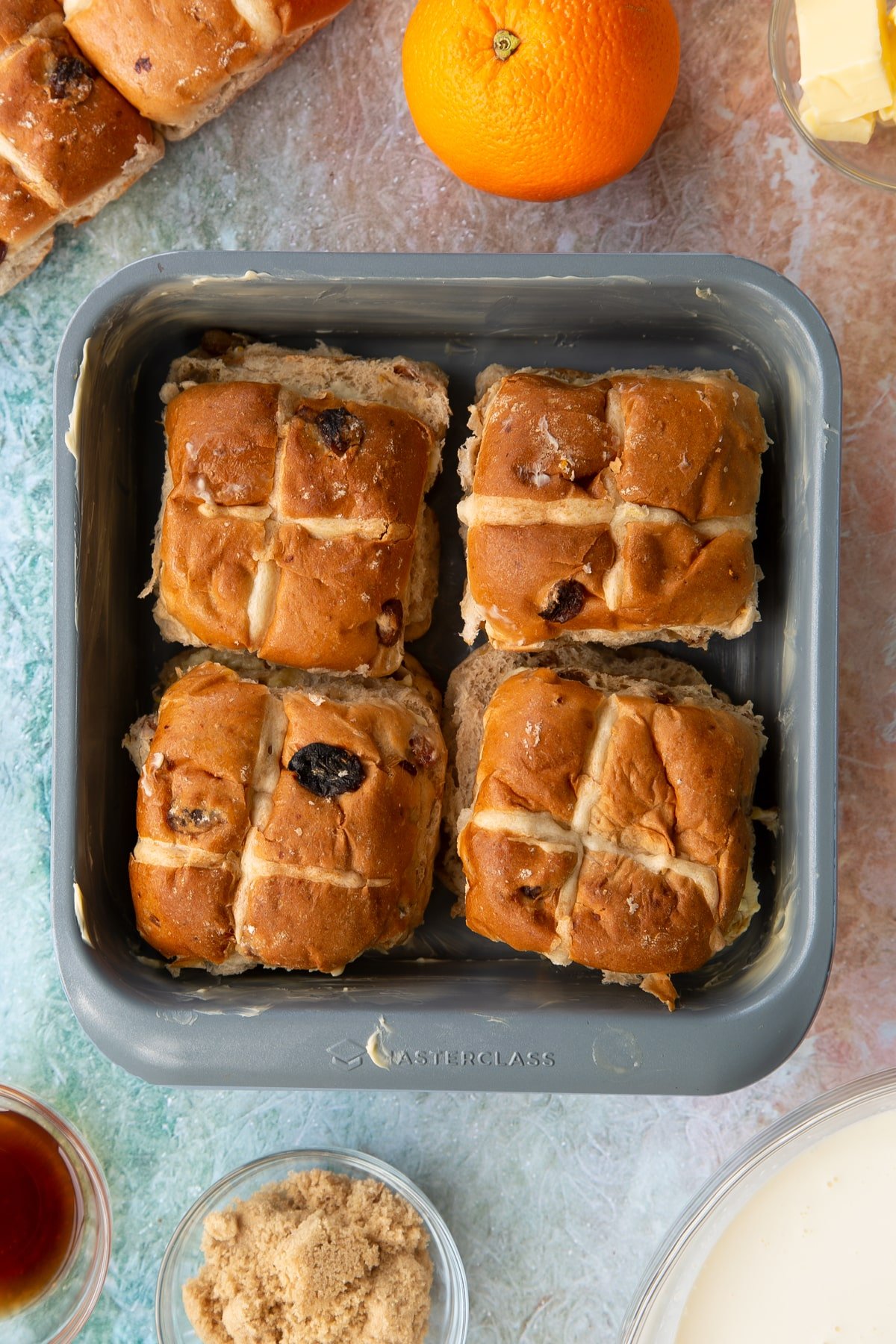 Adding the tops of the hot cross buns to the tin ontop of the bottoms.