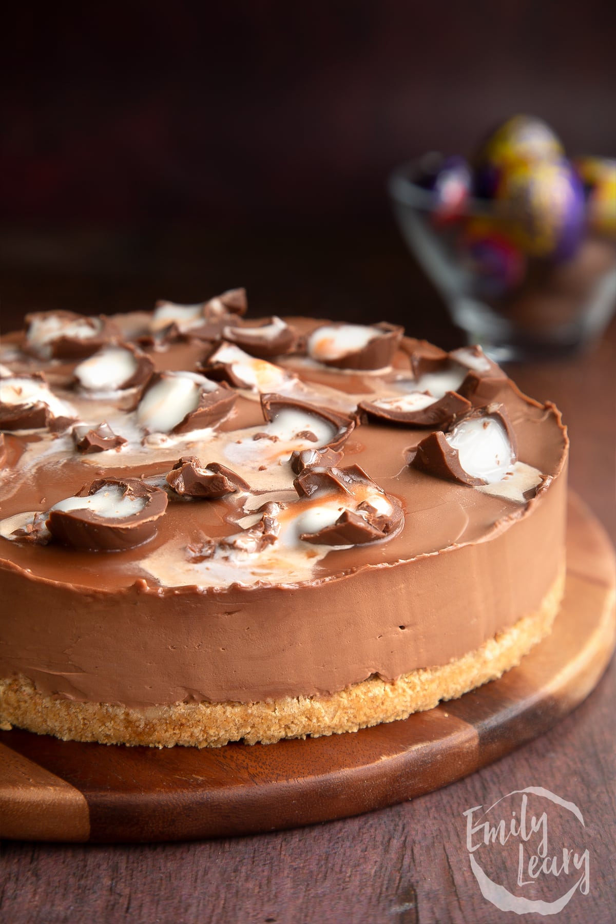 Close up of the finished Cadbury Creme Egg cheesecake on a wooden board.