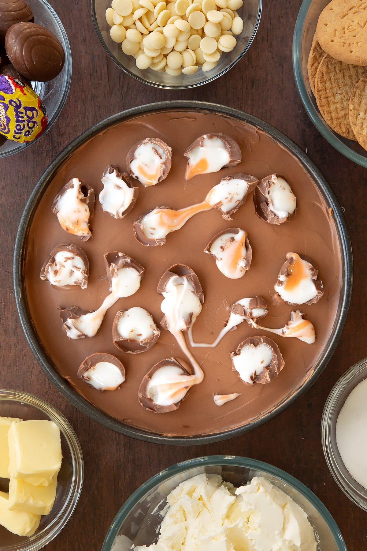 Adding crumbled Cadbury Creme Eggs onto the top of the cheesecake.