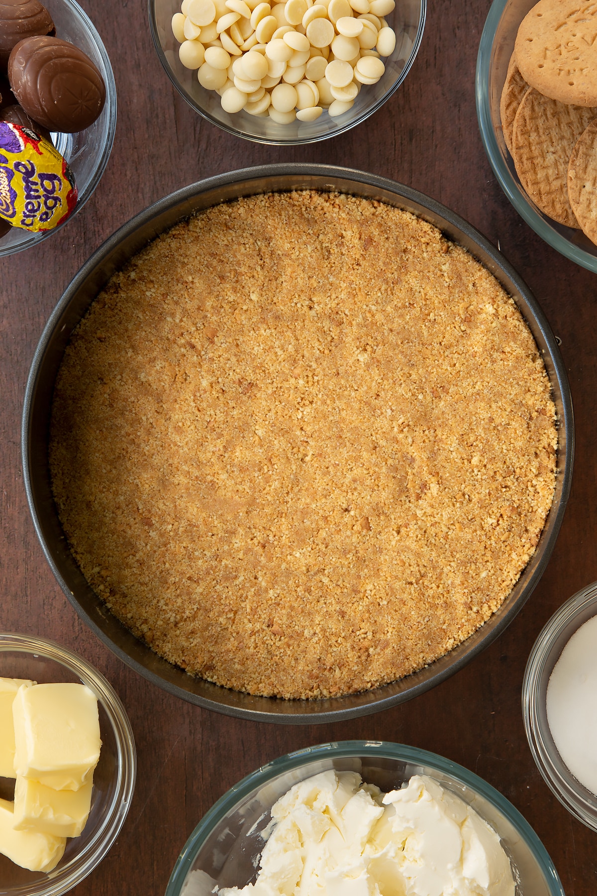 Pushing the biscuit mixture down into the cake tin to form the base of the Cadbury Creme Egg cheesecake.
