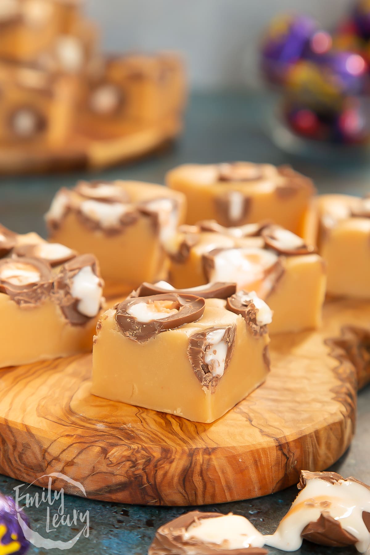 Side on shot of finished slices of Cadbury Creme Egg fudge on a wooden board. 