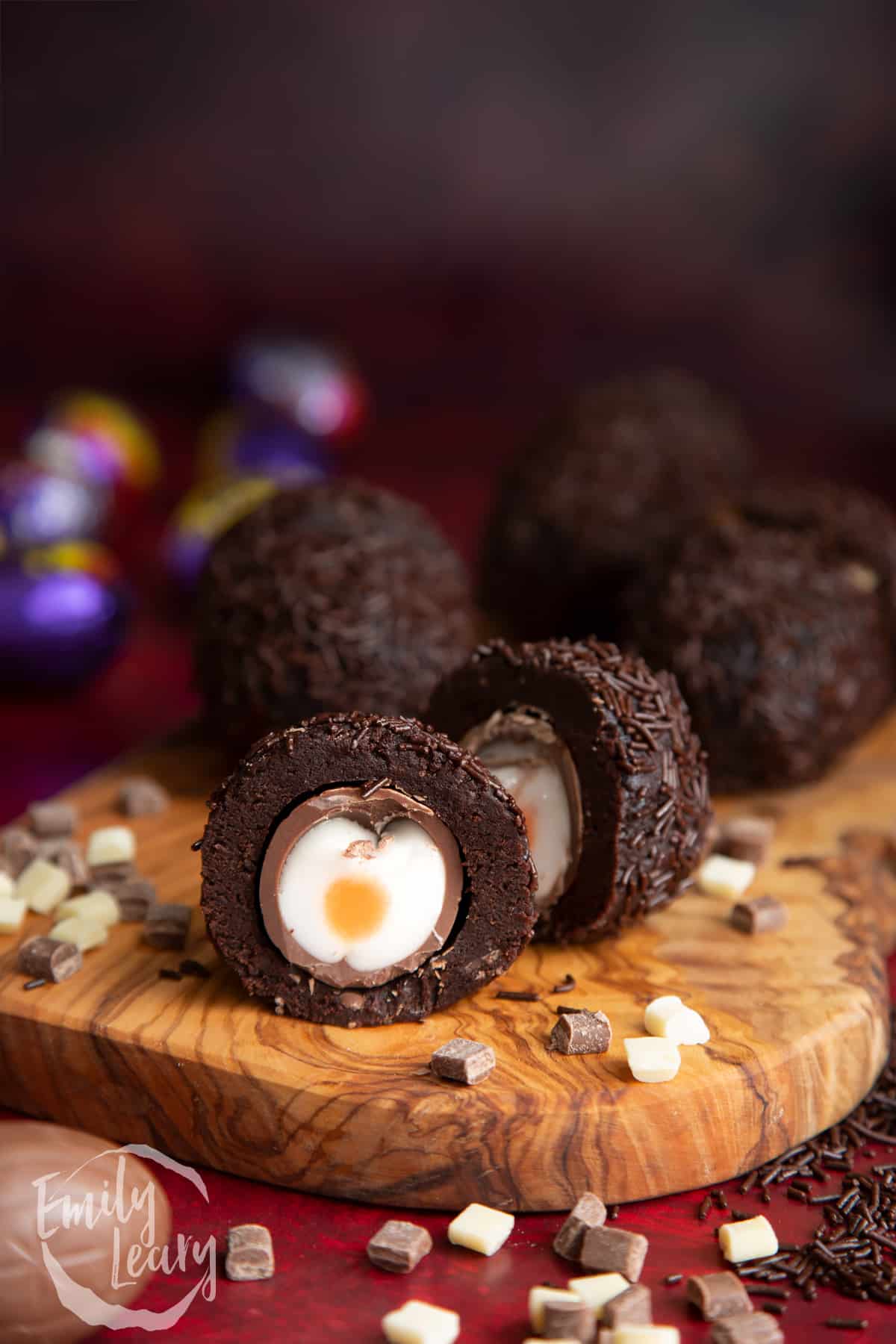 Cut open creme Egg Scotch egg on a wooden board.