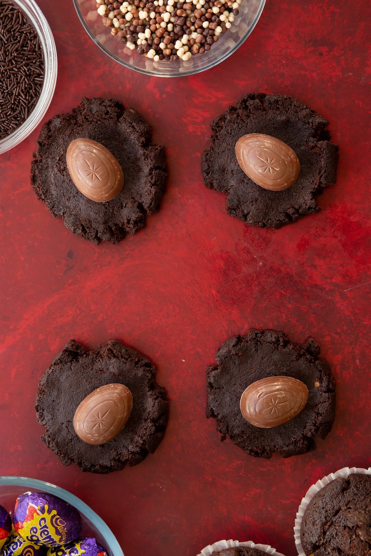 Adding a full size creme egg to the centre of the flattened muffin dough.