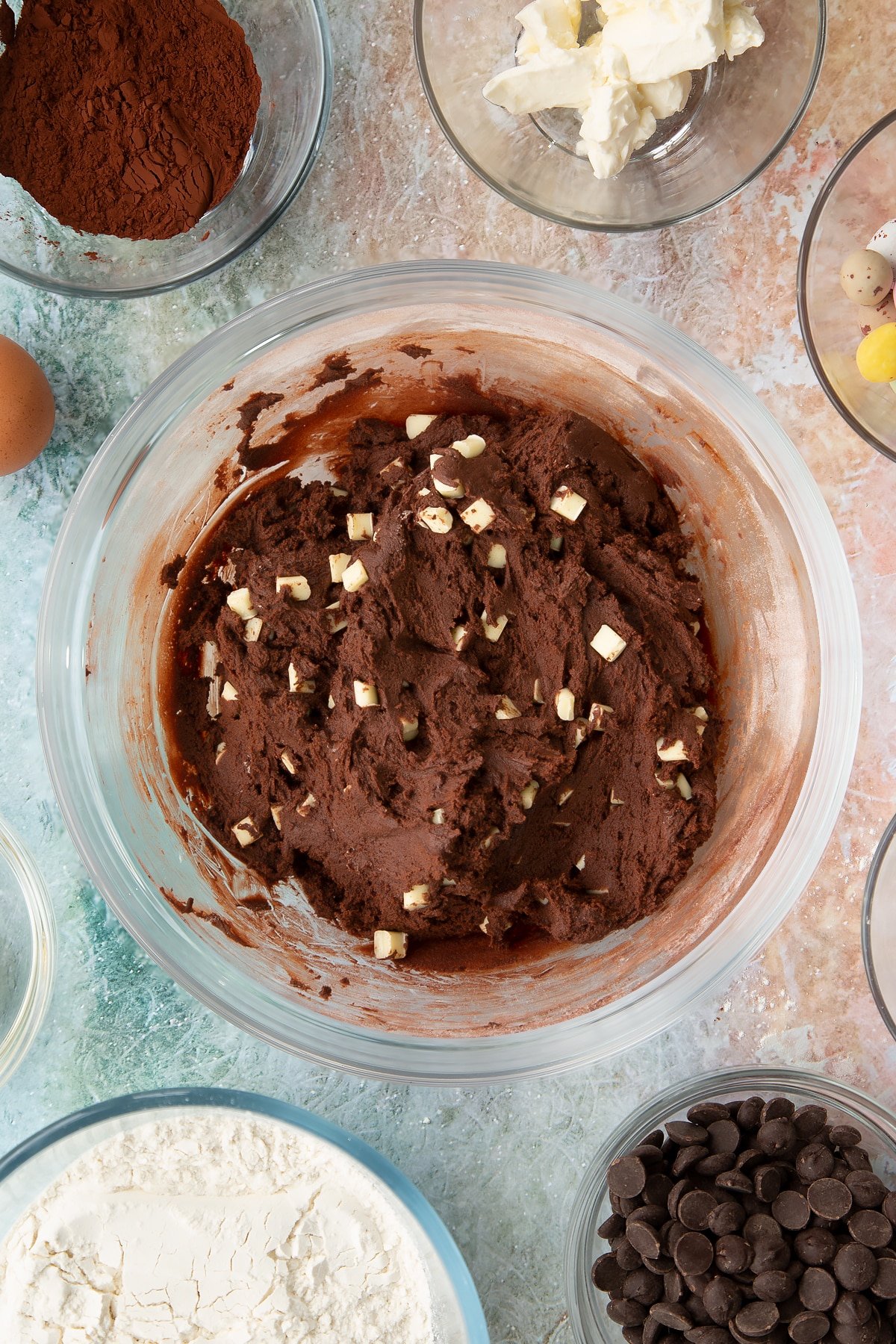 Overhead shot of the mixing bowl after the white chocolate chunks have been mixed into the Easter cheesecake cookie mixture. 